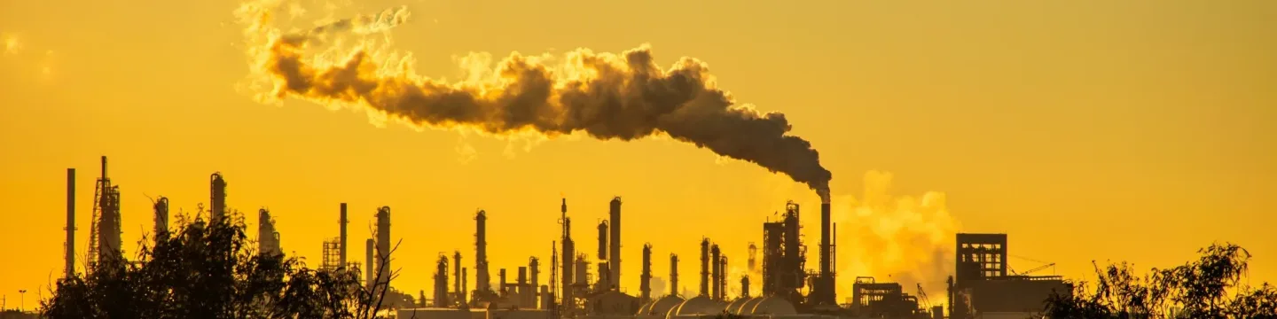 A factory emits a large cloud of pollution into the sky from its chimneys.